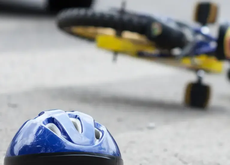 a helmet on the ground next to a fallen bike