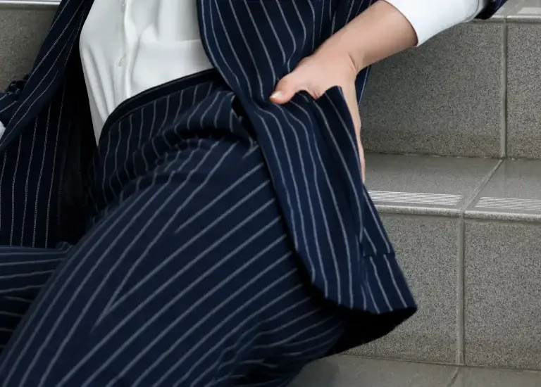 a woman in a suit sitting on some steps