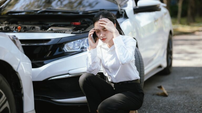 Woman talking on phone after car accident