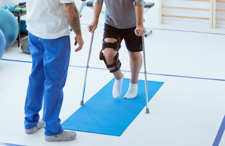 Man after car accident in an orthosis and on crutches