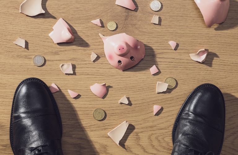 broken piggy bank and coins on the floor