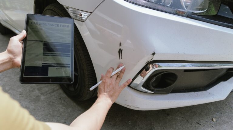 insurance company employee assesses the damage to a car