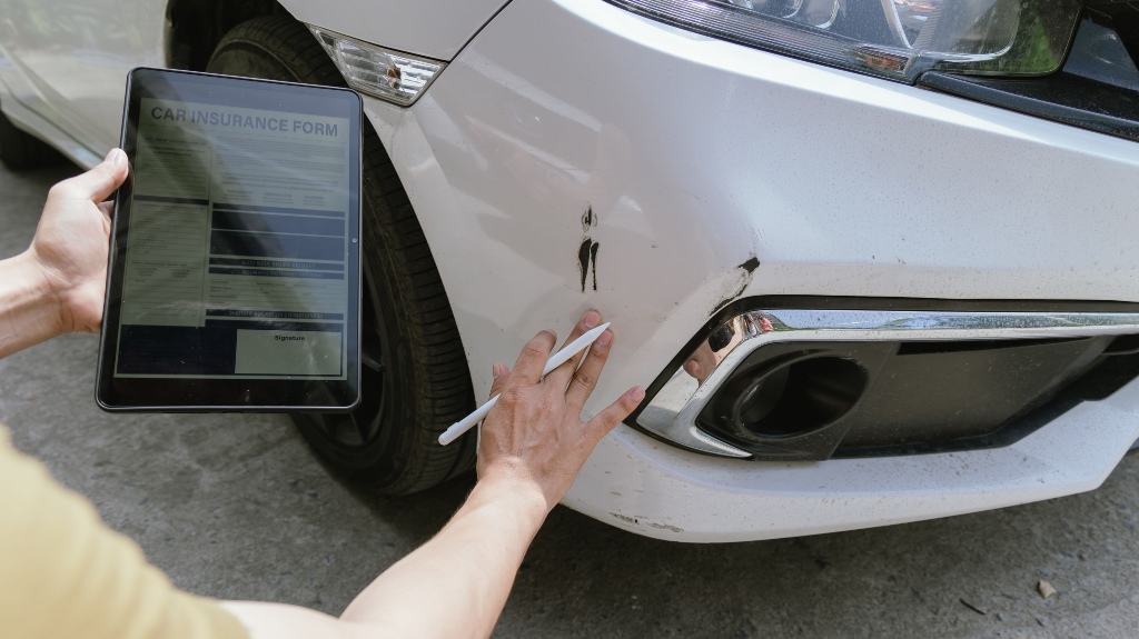 insurance company employee assesses the damage to a car