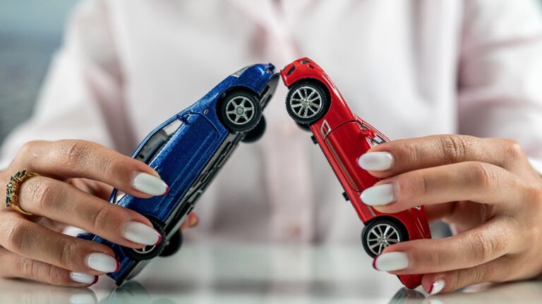 woman simulating an accident with two mini cars on the table