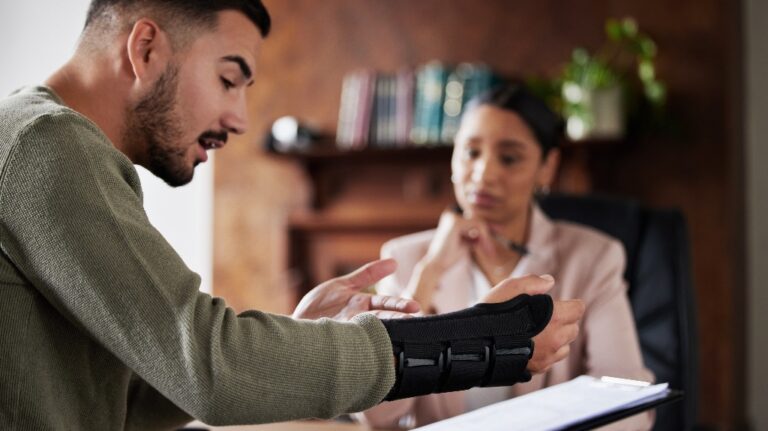 Man with injured hand is consulting with lawyer