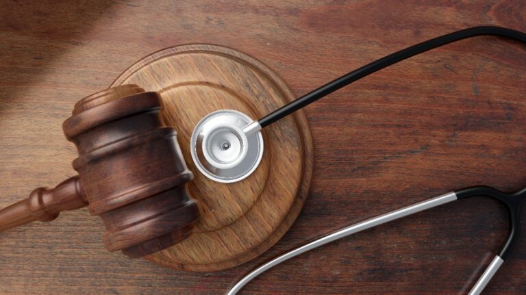 Judge gavel and doctor stethoscope on lawyer office desk