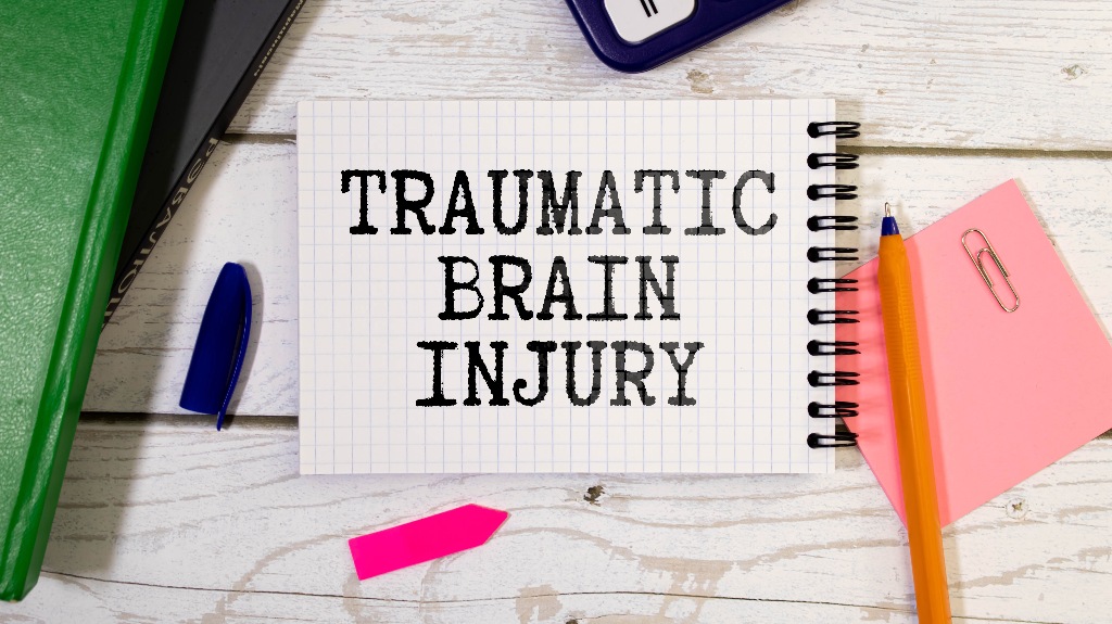 TBI text written in a notebook lying on a desk