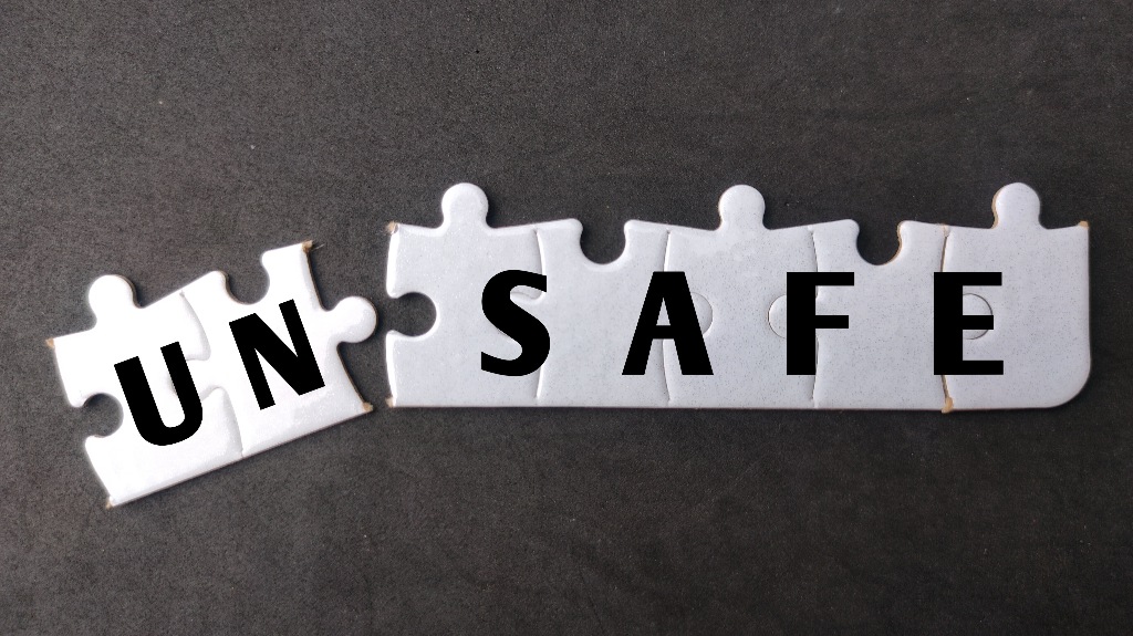 White puzzle with text UN SAFE on black background
